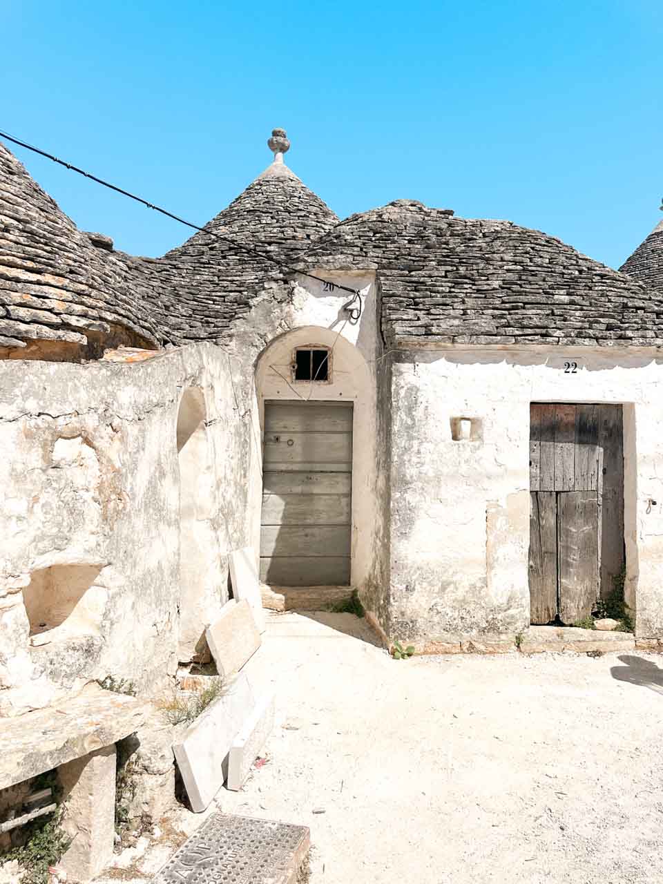 Traditional trulli houses with weathered stone roofs in a quiet corner of Alberobello