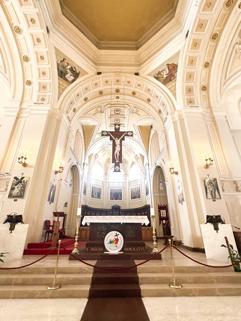 Interior of the Church of Saints Cosmas and Damian with an altar beneath a large suspended crucifix