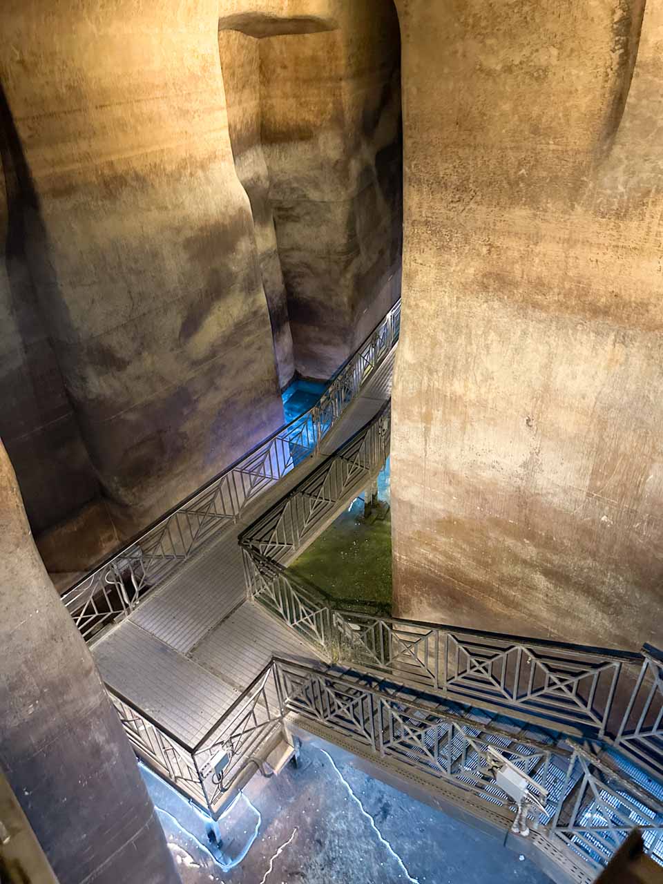 Suspended metal walkways crossing the underground chambers of Palombaro Lungo in Matera