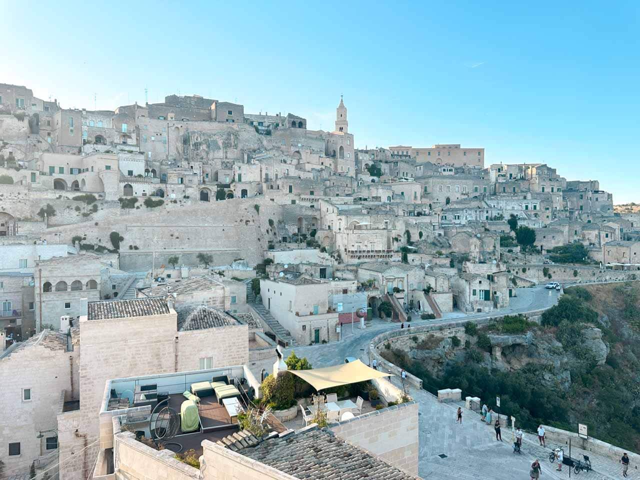 View across the Sassi district and canyon edge lined with historic stone buildings in Matera, Italy