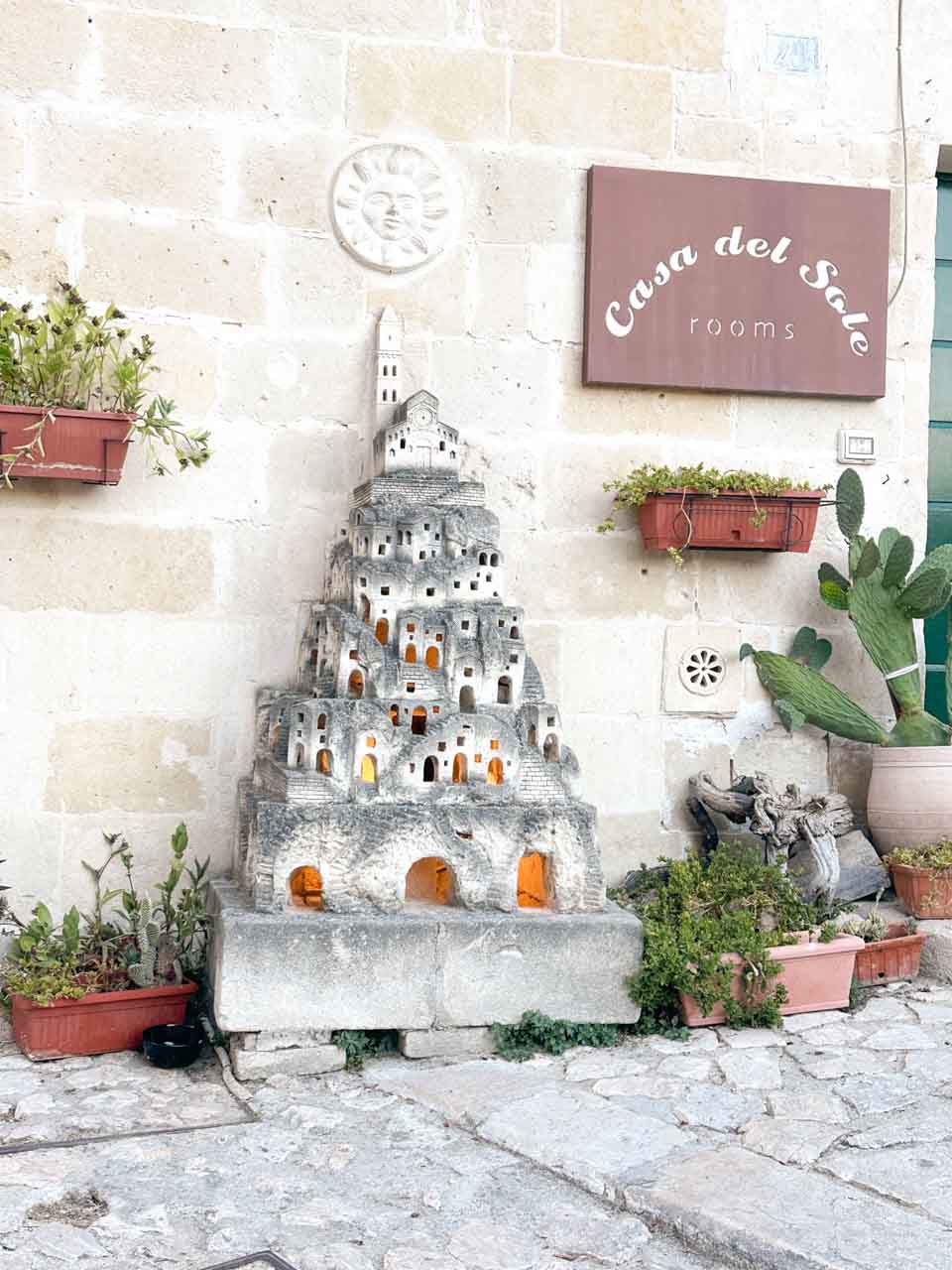 Stone model of the Sassi district displayed outside a guesthouse in Matera, Italy