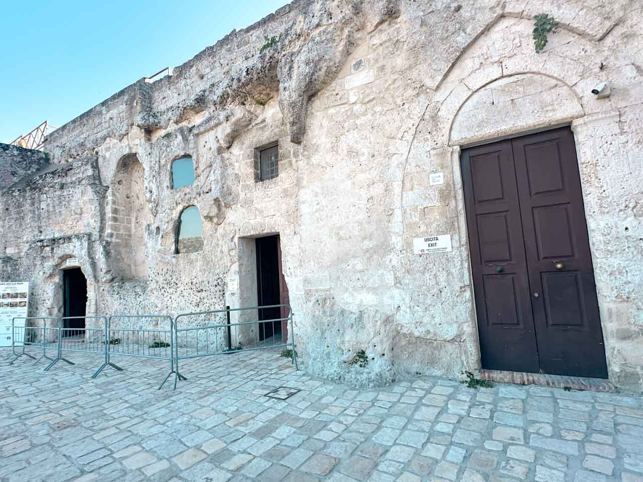 Entrance to a church carved into the limestone cliffs of Matera