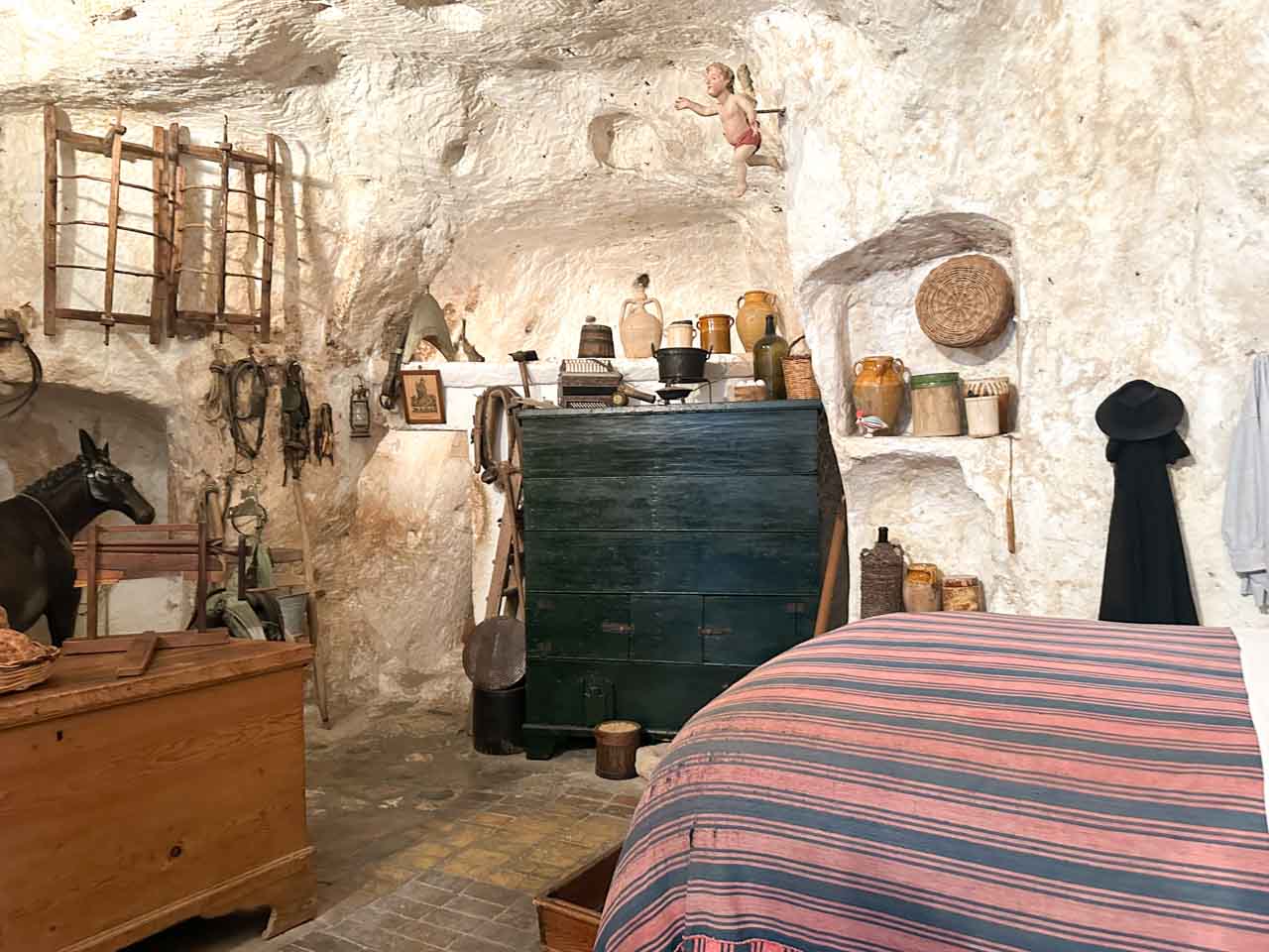 Recreated cave dwelling showing traditional furniture and household items in Matera, Italy