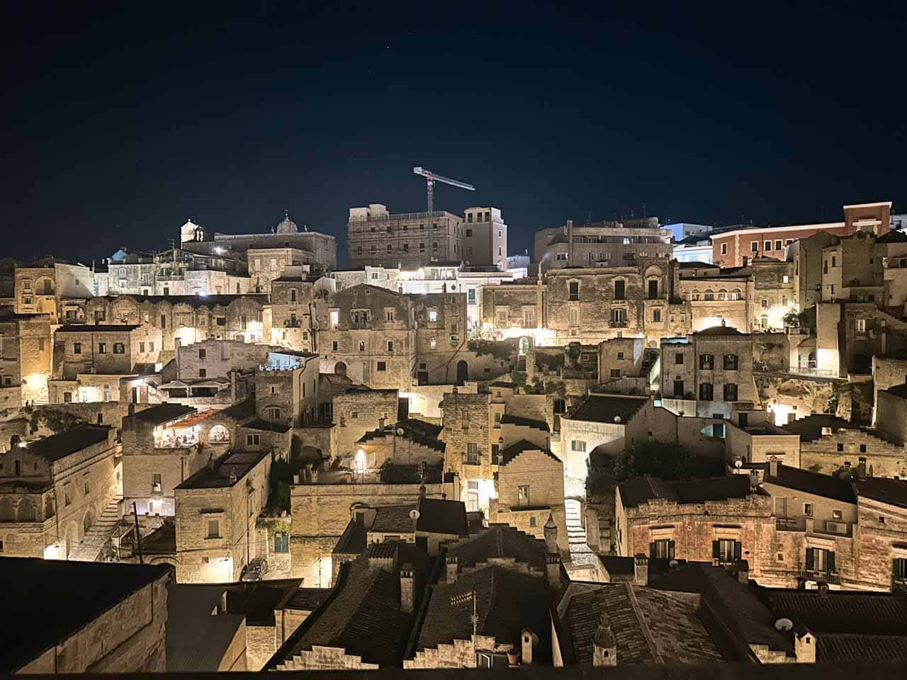 Night view of Matera's Sassi district, with stone houses and churches illuminated after dark