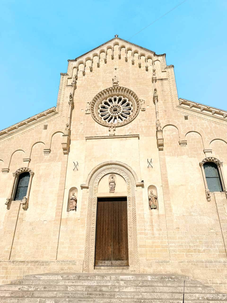 The fa&ccedil;ade of Matera Cathedral viewed from the steps below on a sunny day