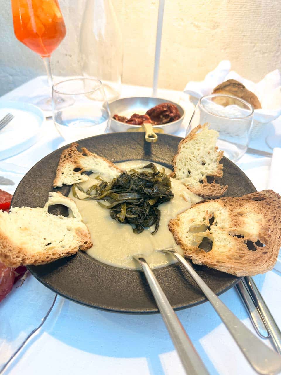 A creamy fava bean pur&eacute;e topped with cooked chicory and served with toasted bread at San Biagio Ristorante in Matera