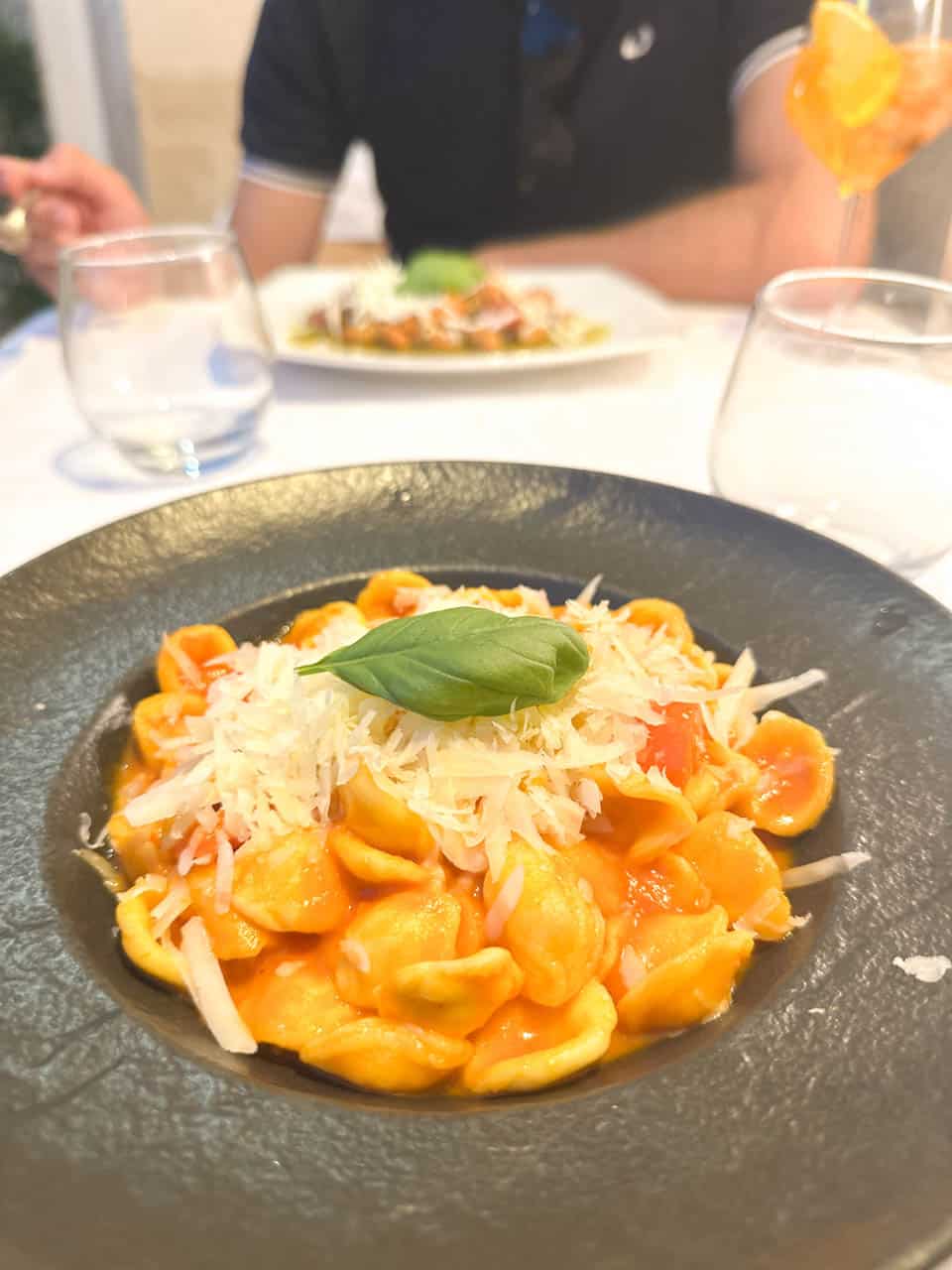 A bowl of orecchiette pasta with tomato sauce, grated cheese, and fresh basil at San Biagio Ristorante in Matera, Italy