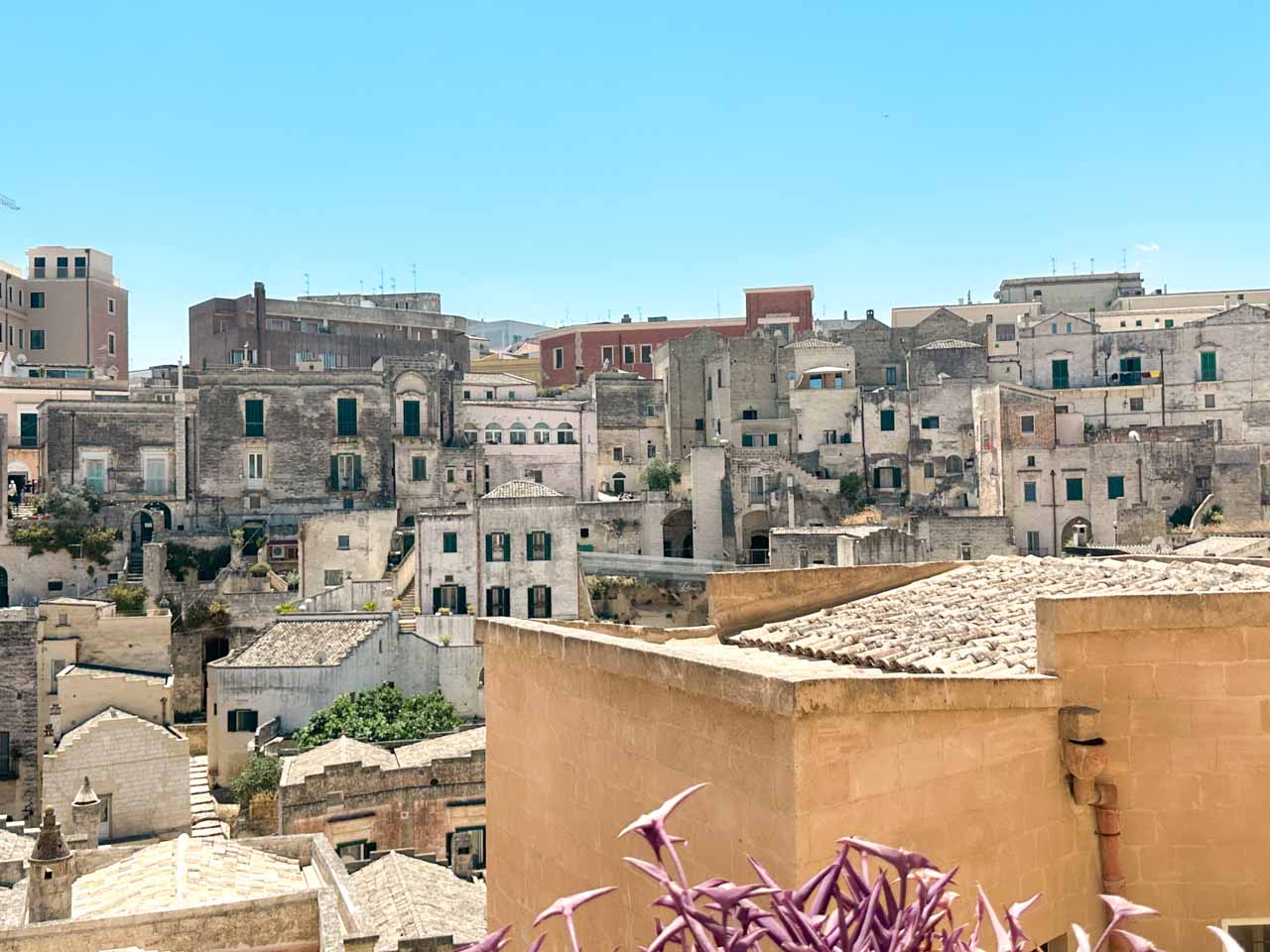 A view across the rooftops and stone houses of the Sassi di Matera on a sunny day