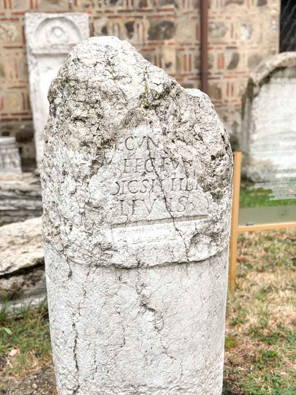 Weathered ancient stone with a Latin inscription outside the National Archaeological Museum in Sofia, Bulgaria