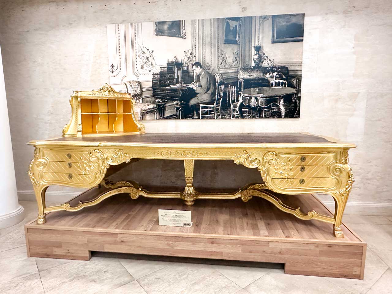 Ornate gold desk displayed alongside a historic photograph at the Regional History Museum in Sofia