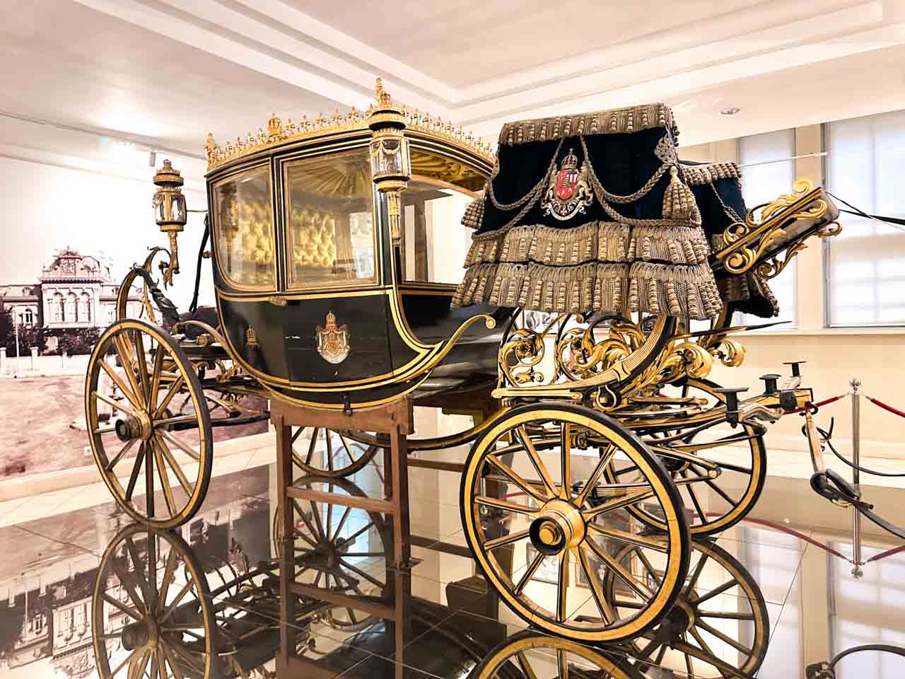 Ornate black and gold horse-drawn carriage from the Palace of Versailles displayed at the Regional History Museum in Sofia, Bulgaria