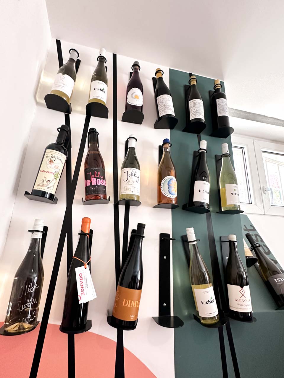 Bottles of Bulgarian wine arranged on wall-mounted holders inside the Wine Generator wine shop in Sofia