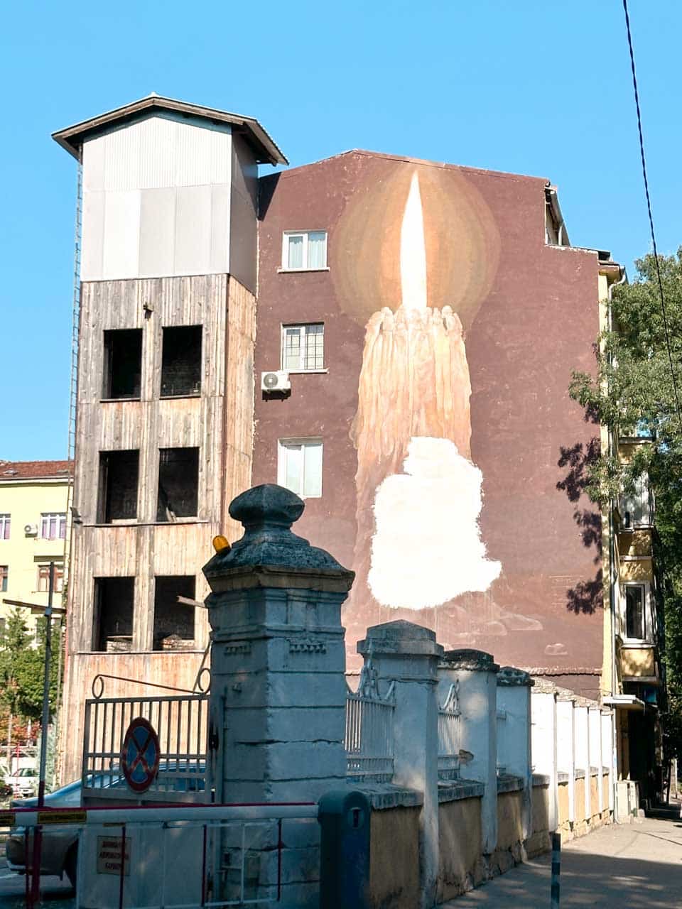 Large mural of a burning candle painted on the side of a residential building in Sofia, Bulgaria