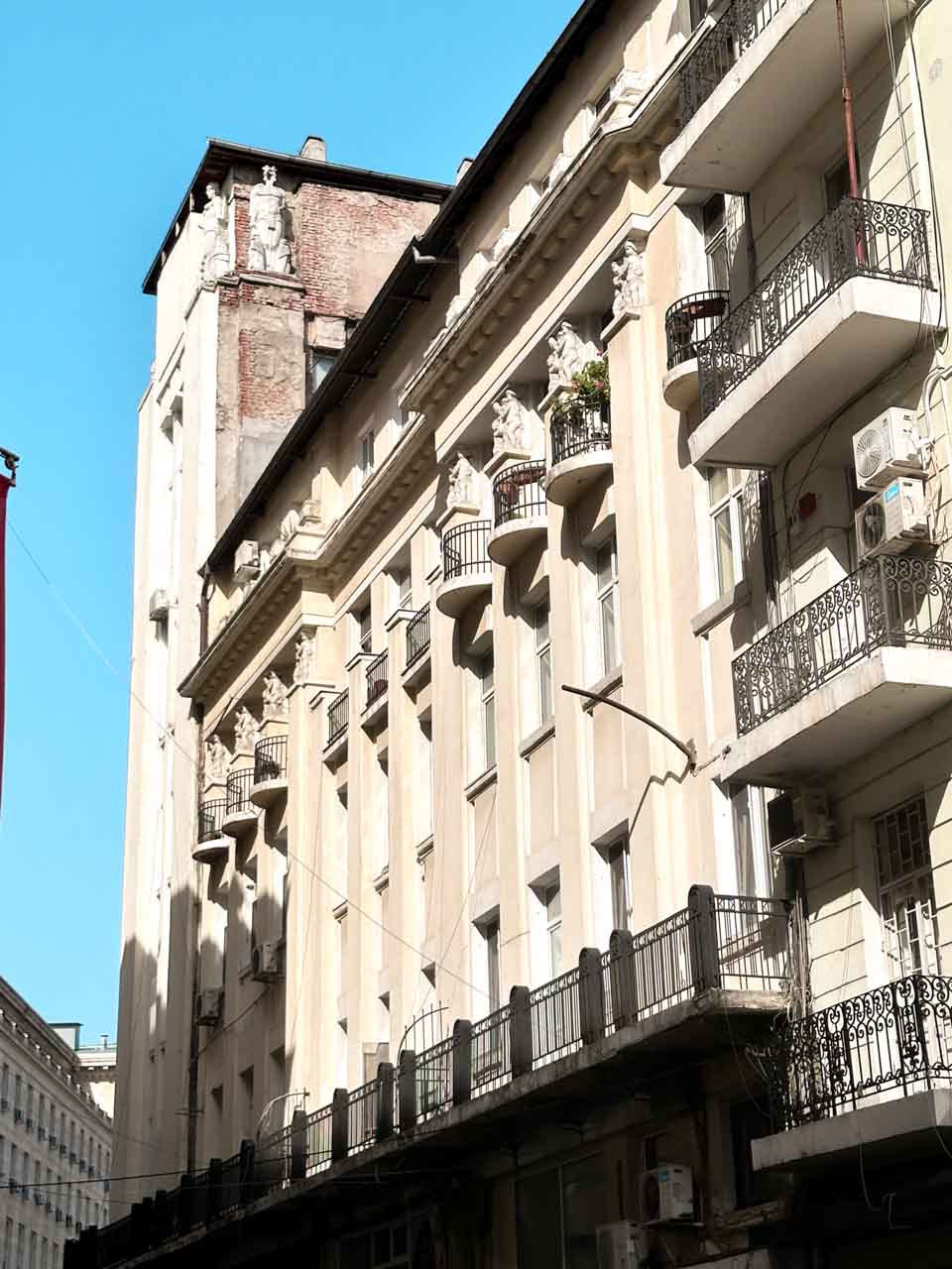 An ornate historic building in central Sofia with rows of small curved balconies and sculpted figures along its fa&ccedil;ade