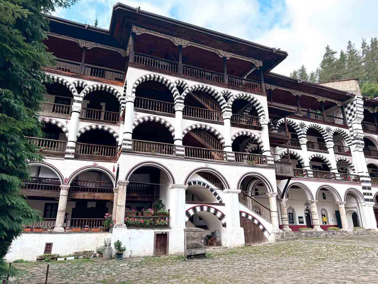 Multi-storey buildings at Rila Monastery, with rows of striped arches and wooden balconies