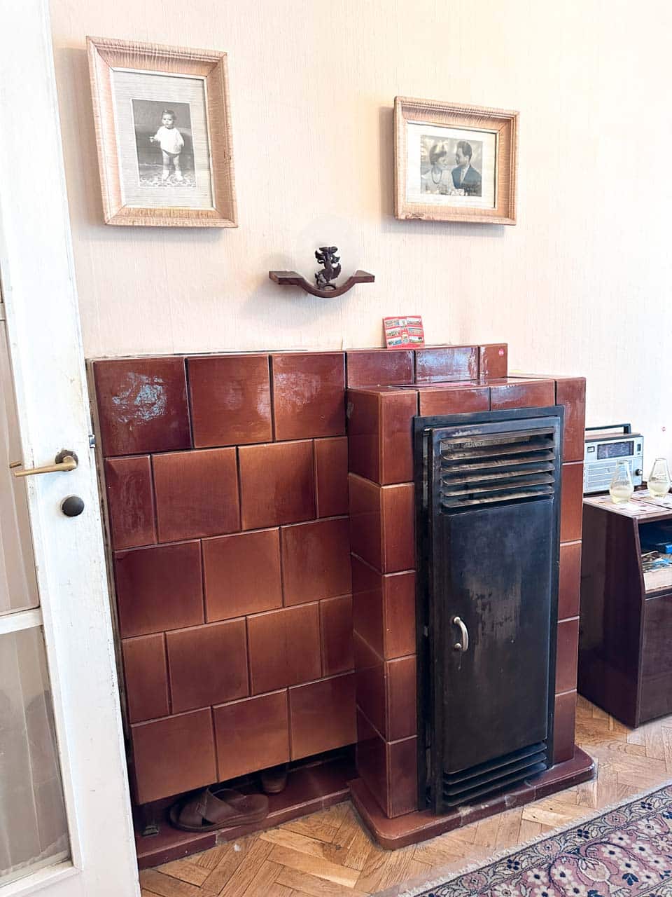 Retro tiled heater with framed family photographs at the Red Flat museum in Sofia