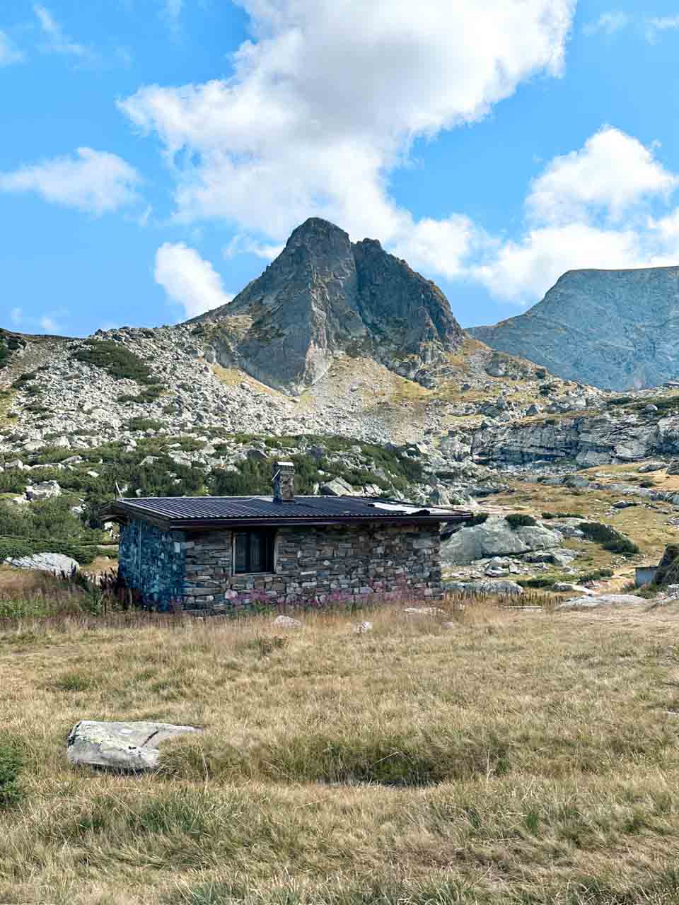 Rocky mountain peak and a small stone hut in the Rila Mountains, Bulgaria