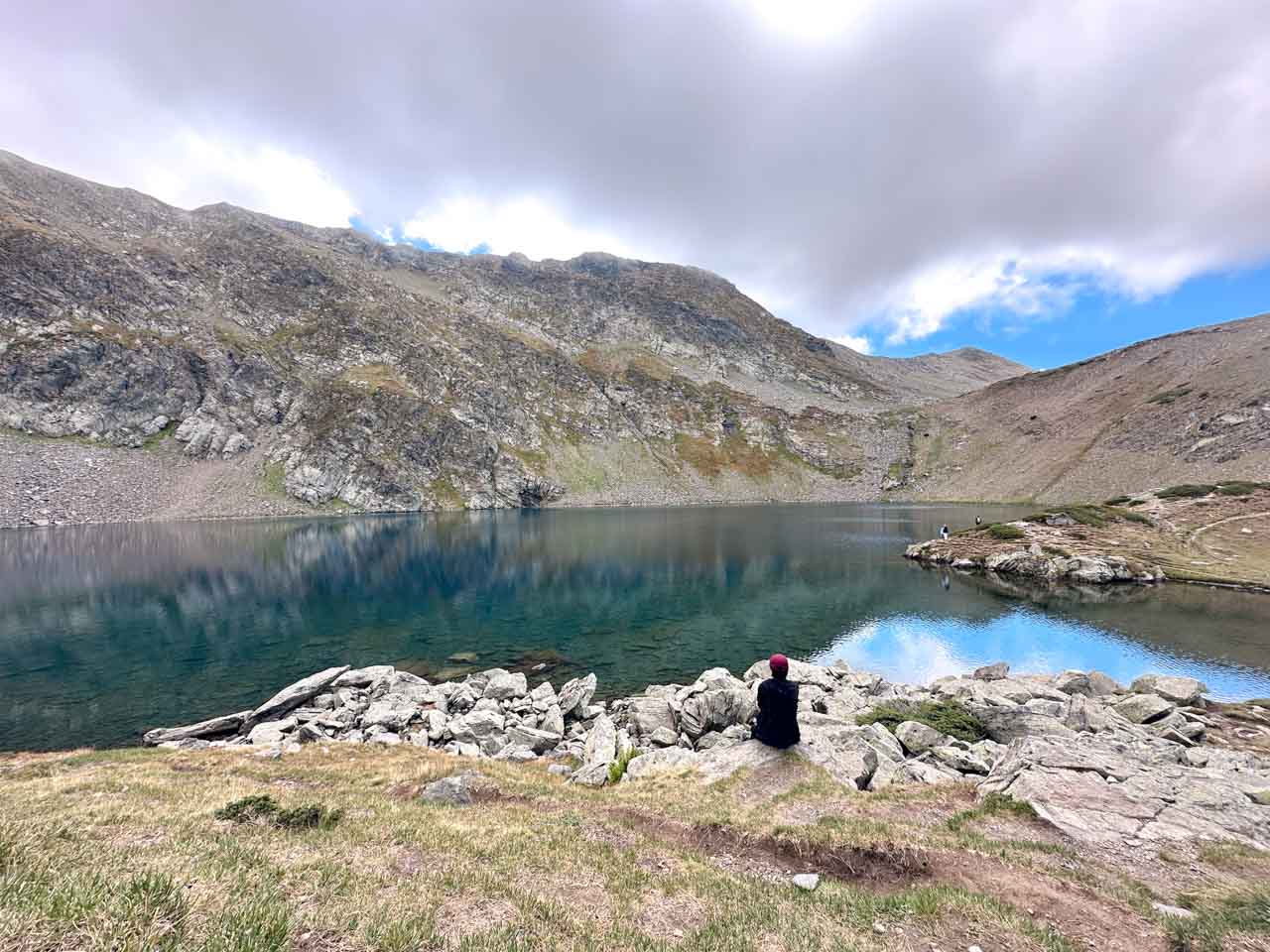Hiker sitting beside one of the Seven Rila Lakes in Bulgaria's Rila Mountains