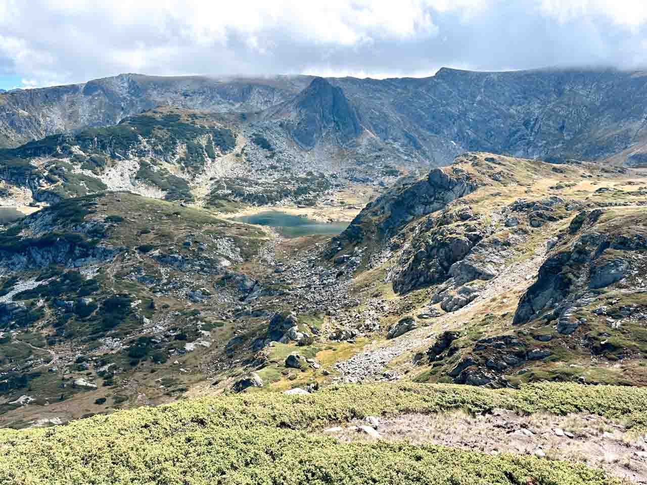 Rocky mountain landscape with one of the Seven Rila Lakes visible in the distance