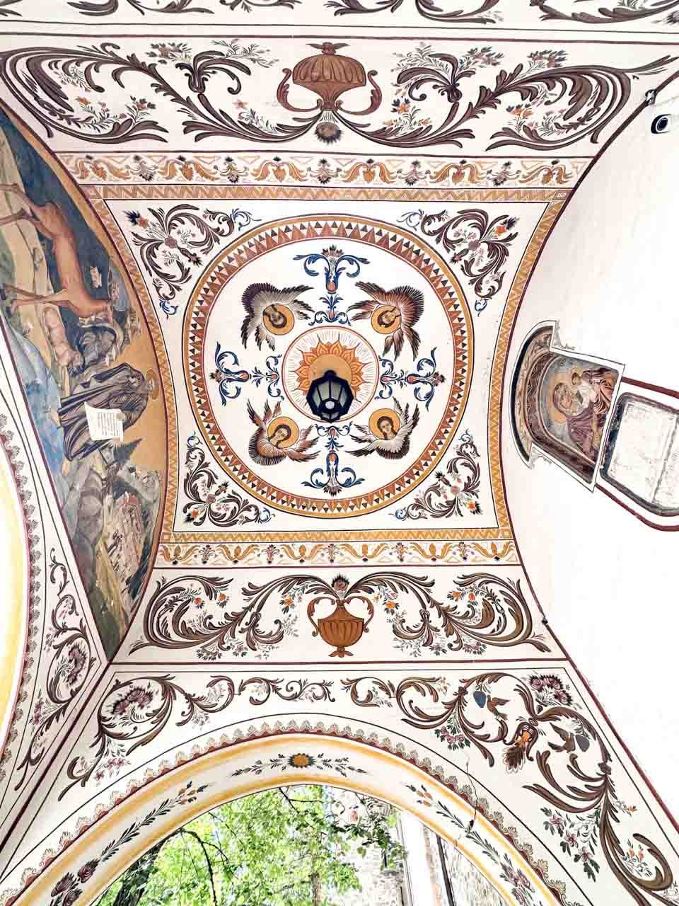 Decorative painted ceiling with floral patterns and religious imagery at Rila Monastery in Bulgaria