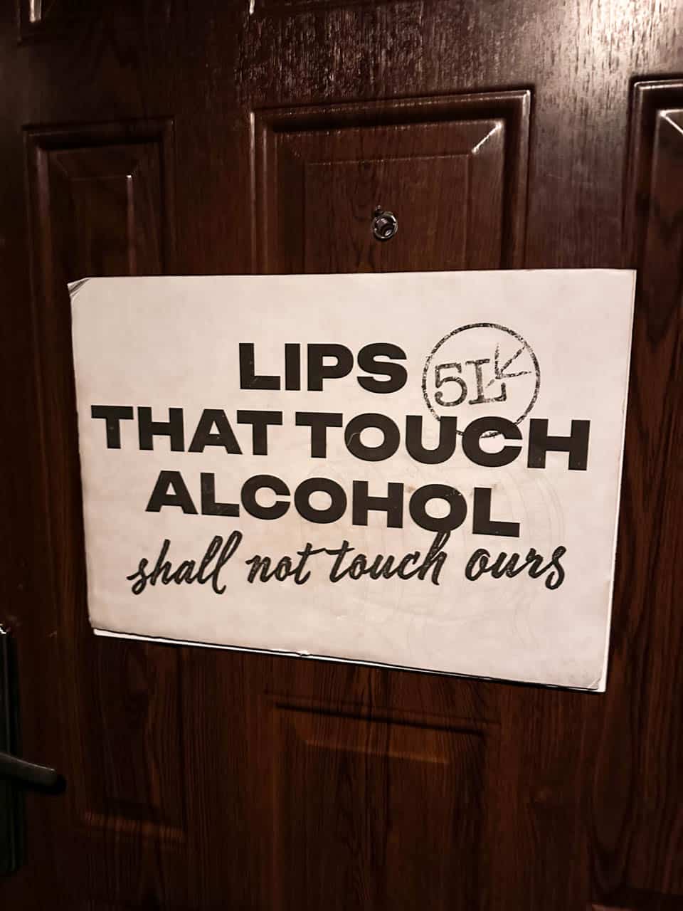 A sign on the entrance to 5L Speakeasy Bar in Sofia reading &ldquo;Lips that touch alcohol shall not touch ours&rdquo;