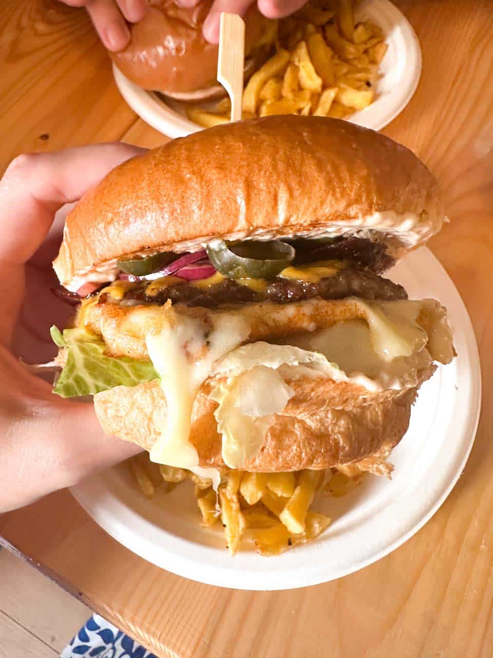 A cheeseburger with lettuce, red onion, and jalape&ntilde;os, served with chips at Skapto in Sofia