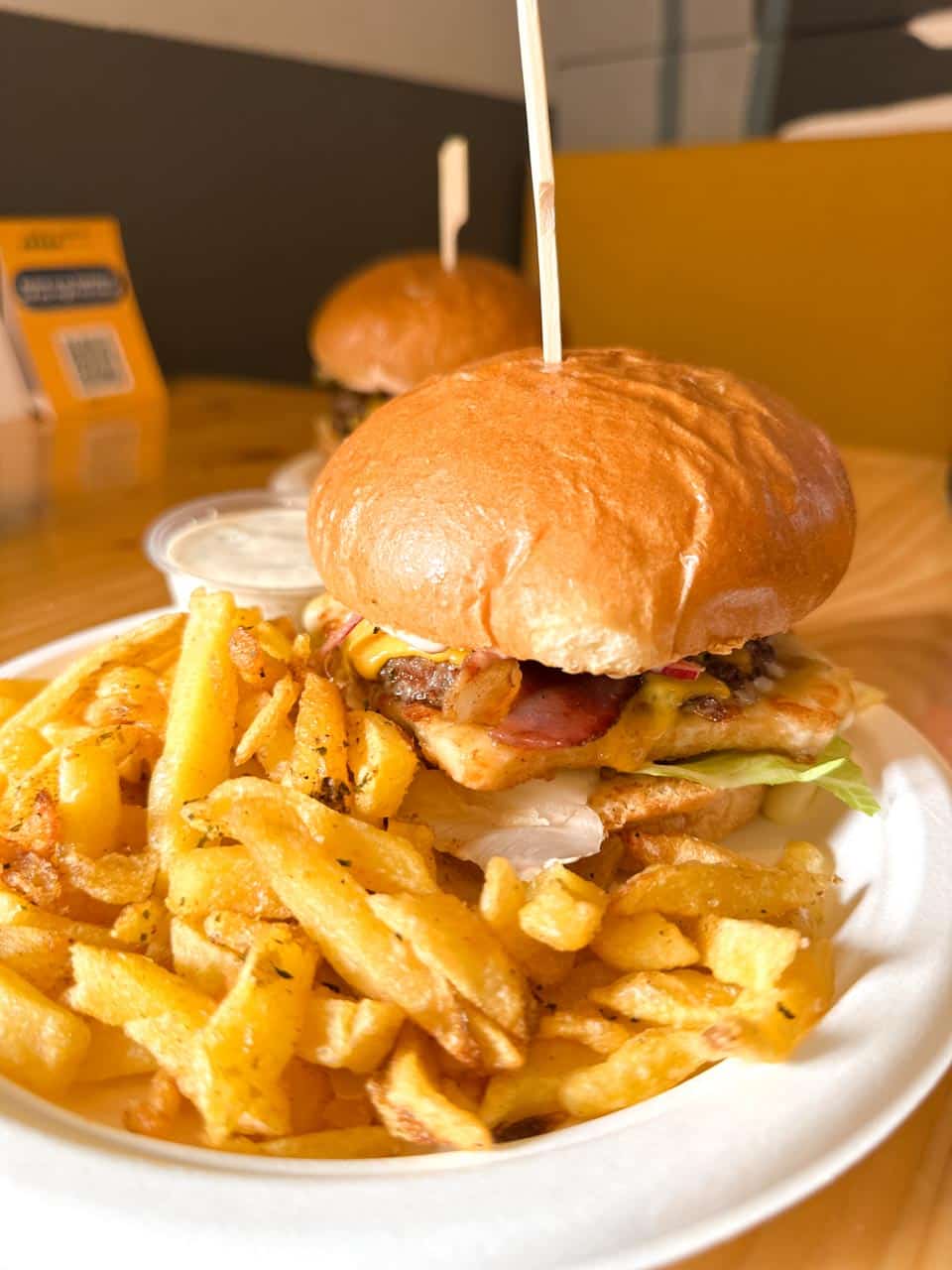 A burger loaded with cheese and bacon, served with a generous portion of chips at Skapto in Sofia