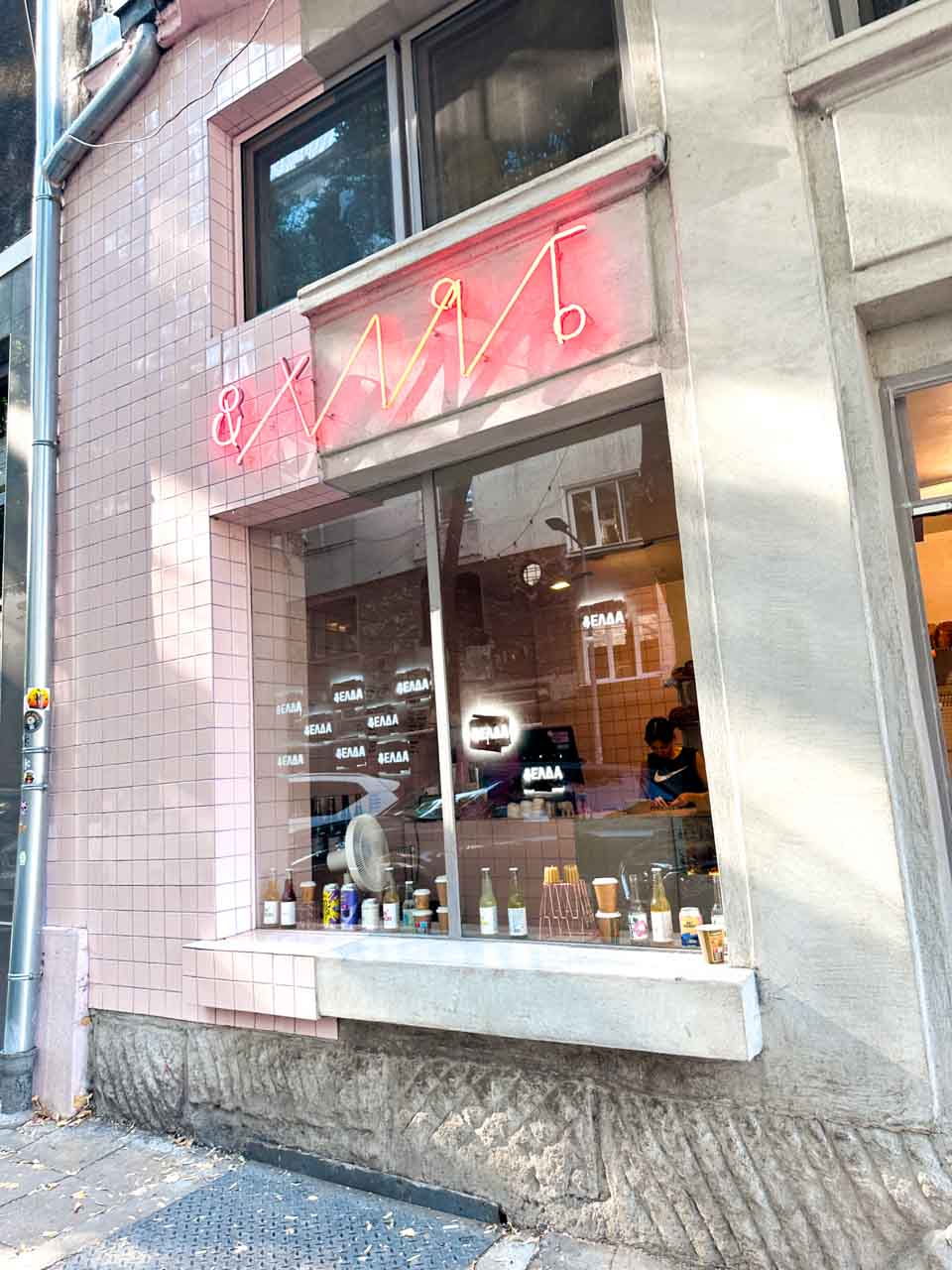 The pink-tiled exterior of &hlyab (&bread) in Sofia, Bulgaria, with its neon sign above the window