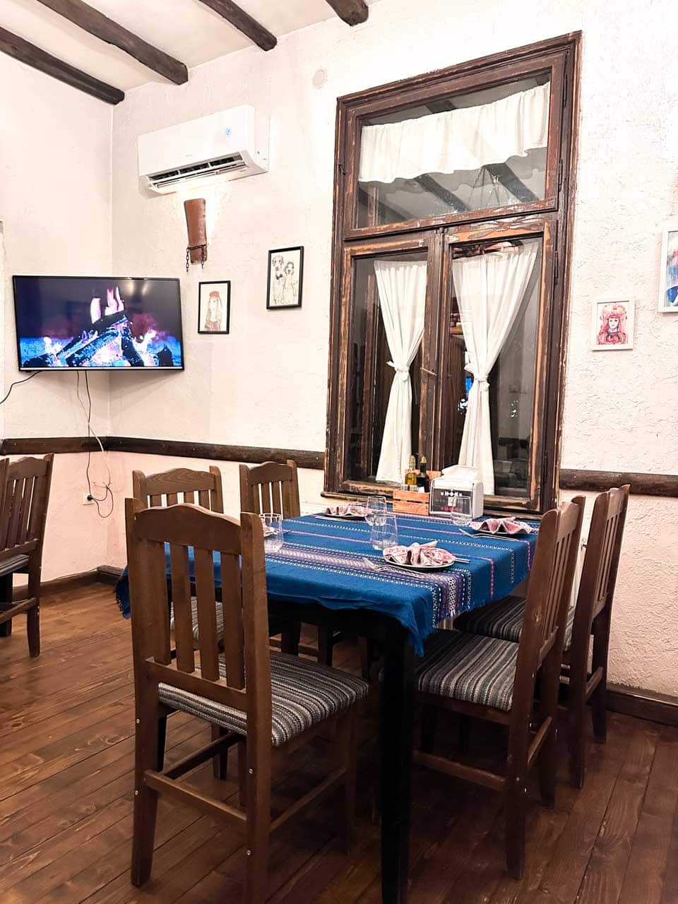 The traditional Bulgarian-style interior of Manastirska Magernitsa in Sofia, with wooden furniture and colourful woven tablecloths