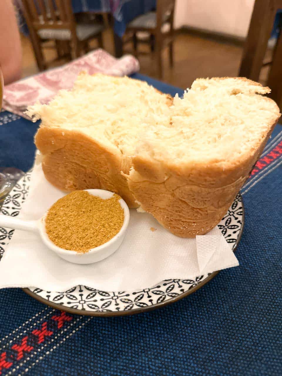 Thick slices of homemade bread served with a small bowl of seasoning at Manastirska Magernitsa in Sofia, Bulgaria
