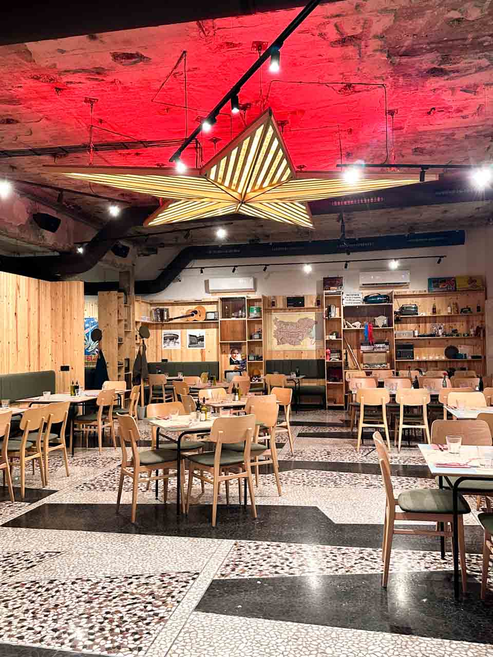 Interior of Raketa Rakia Bar in Sofia with a large illuminated star hanging from the ceiling