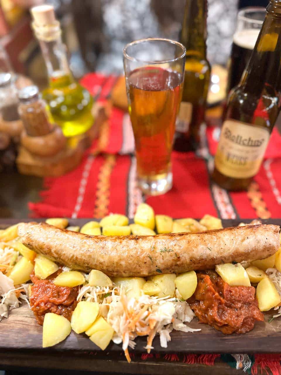 Traditional Bulgarian sausage with potatoes, cabbage salad, and lyutenitsa at Hadjidraganov's Cellars Restaurant in Sofia, Bulgaria