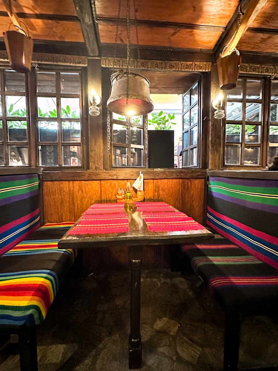 Traditional Bulgarian-style dining area with colourful woven seating at Hadjidraganov's Cellars Restaurant in Sofia, Bulgaria