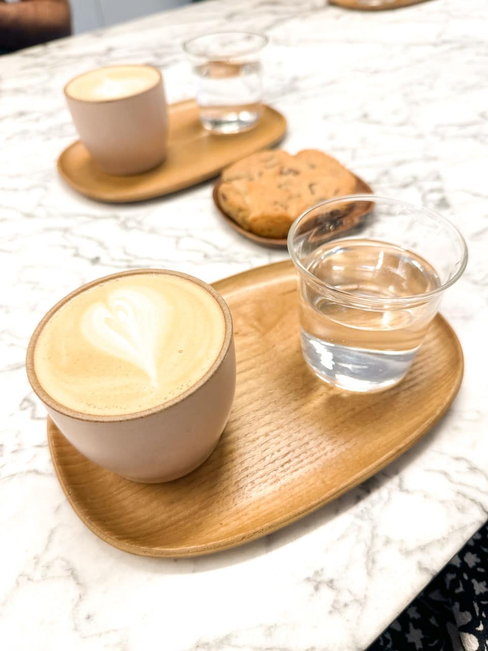 Two cups of coffee served with glasses of water and a cookie at Drekka in Sofia, Bulgaria