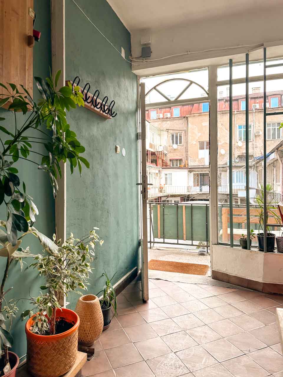 Plant-filled entrance and balcony inside Izzy's Coffee and Brunch in Sofia, Bulgaria