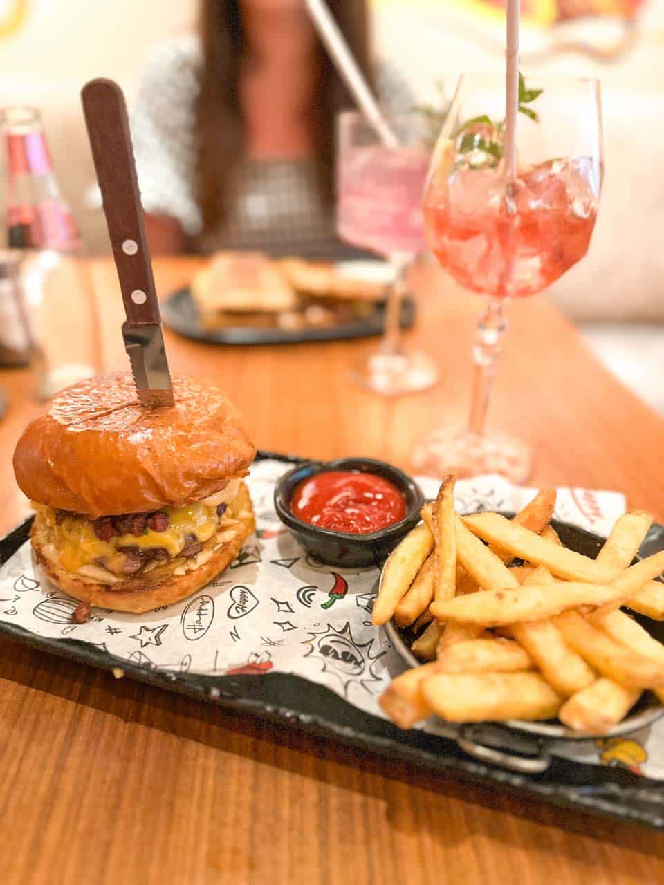 Cheeseburger with chips and a pink cocktail at Happy Bar & Grill restaurant in Sofia, Bulgaria