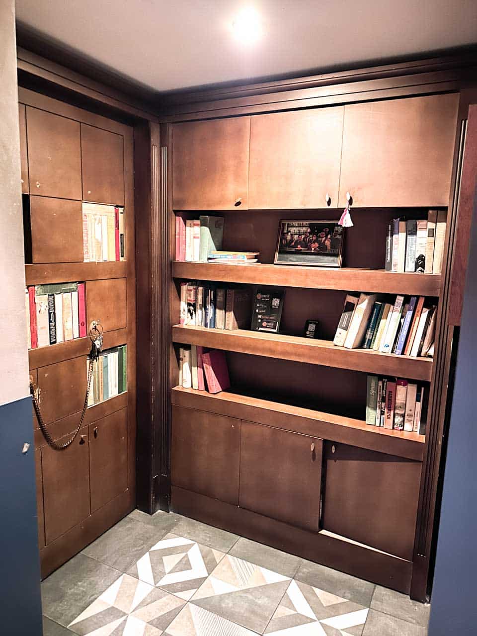 A small bookshelf filled with books by the entrance to 5L Speakeasy Bar in Sofia, Bulgaria