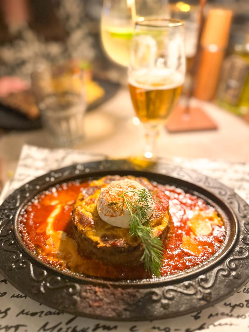 Moussaka served in tomato sauce with yoghurt and fresh dill at Shtastlivetsa Restaurant in Sofia