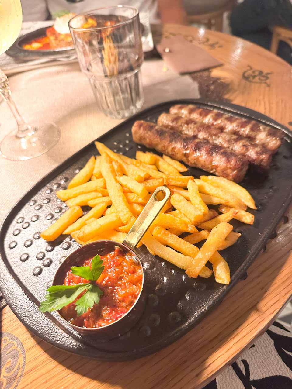 Grilled kebapche with chips and a tomato and pepper dip at Shtastlivetsa Restaurant in Sofia