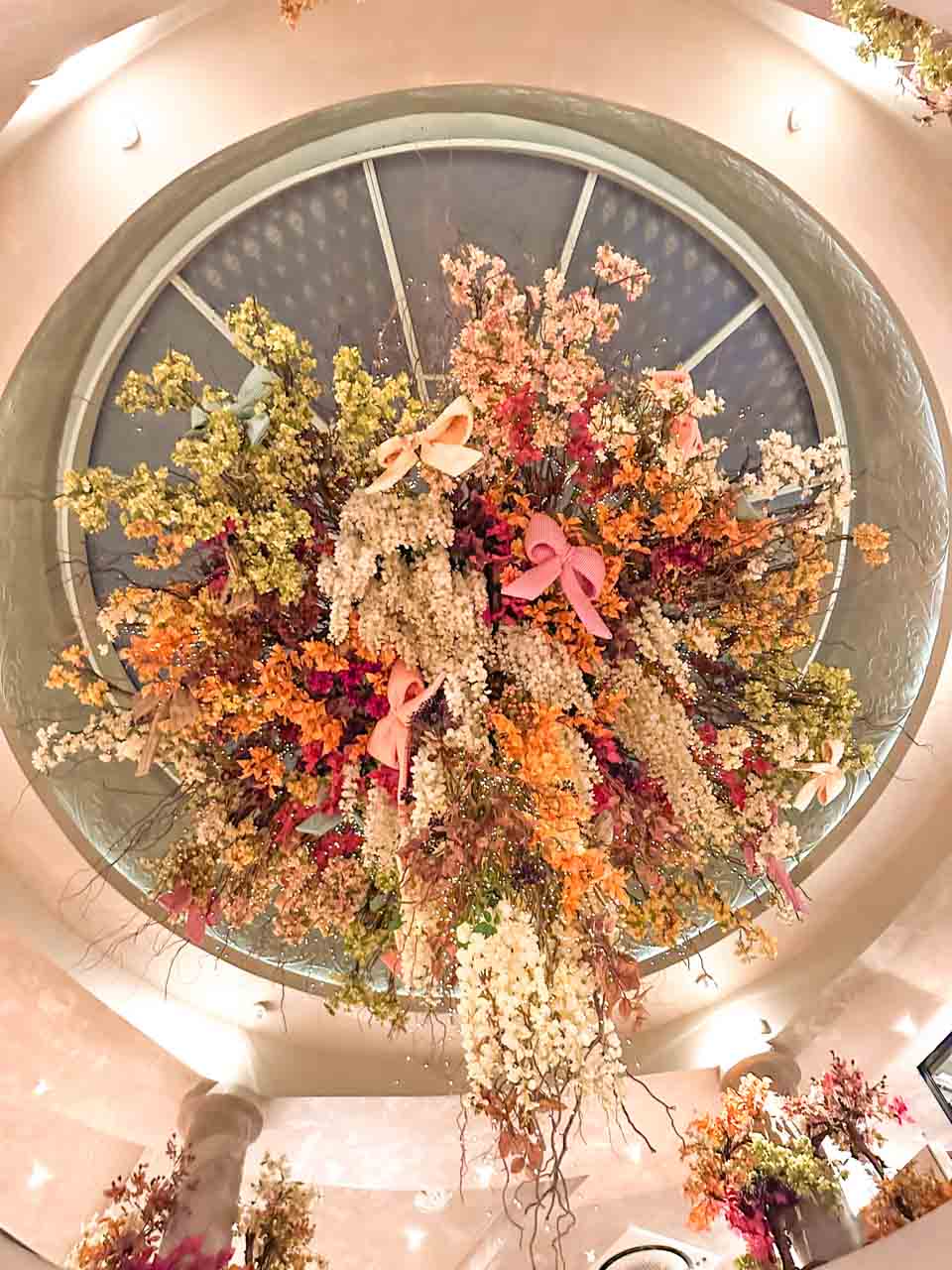 Colourful hanging floral installation beneath the glass-domed ceiling at Shtastlivetsa Restaurant in Sofia