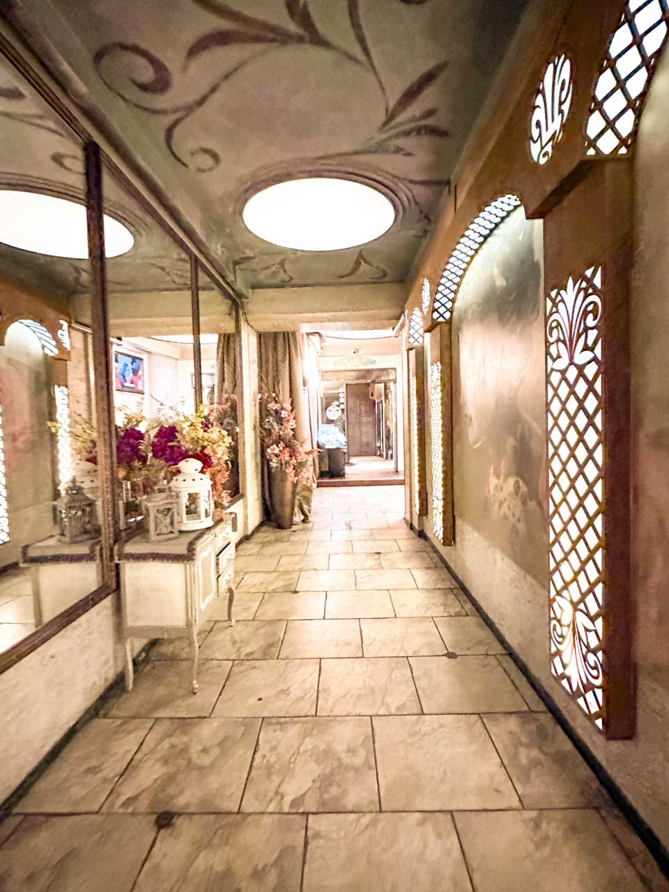 Decorative interior corridor at Shtastlivetsa Restaurant in Sofia with mirrors, flowers, and illuminated wall panels